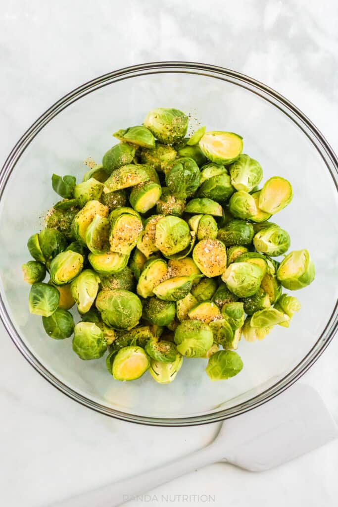 brussels sprouts in a glass bowl with garlic powder